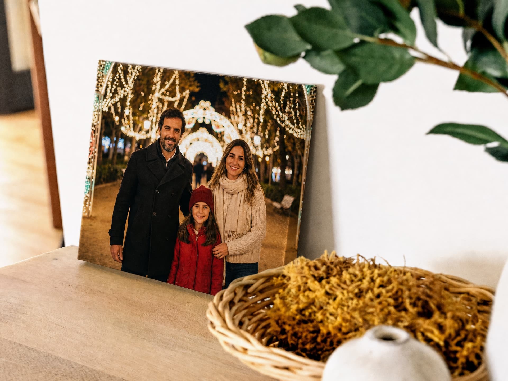 A canvas print of a family portrait displayed on a wooden shelf