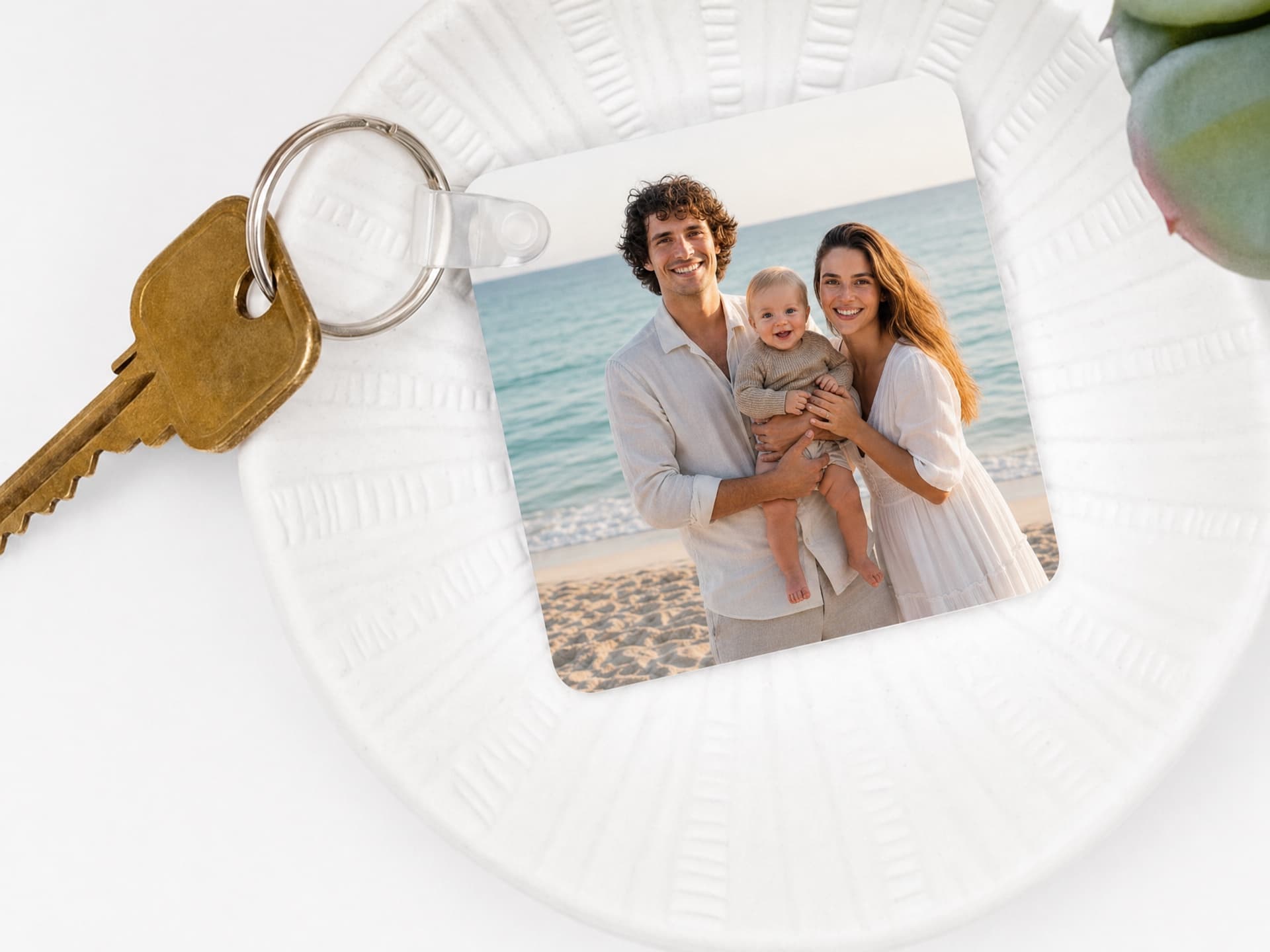 A photo keychain featuring parents and their baby at the beach